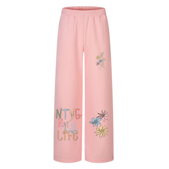 Wide-leg sweatpants in pink with graffiti lettering and colorful daisy floral print on the leg
