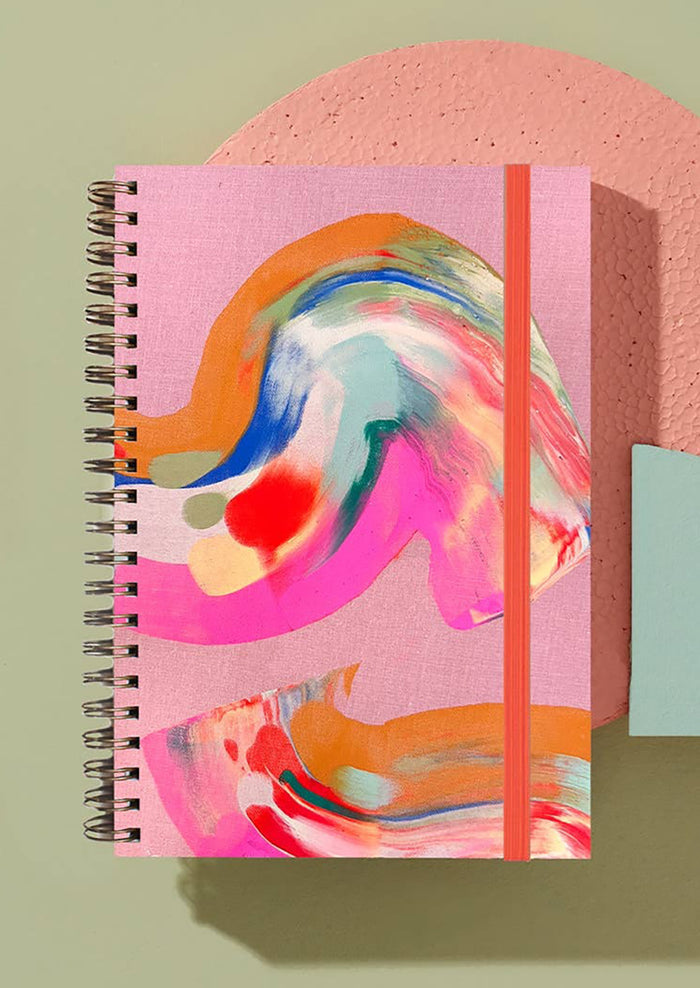 A multicolor painted notebook in pink.