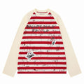 Cream raglan long sleeve tee with red stripes, graffiti print, and graphic patches on front