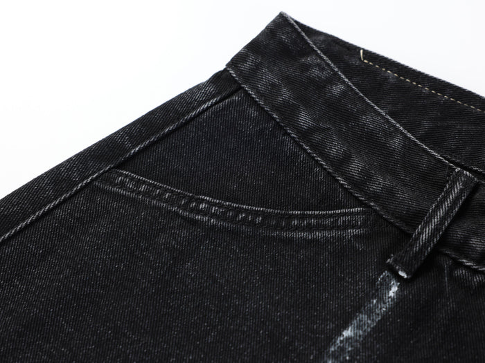 Close-up of black denim waistband seam and stitching on the upper back