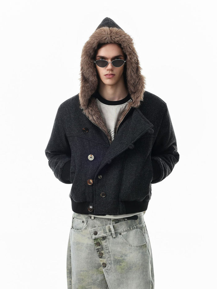 Black hooded bomber jacket worn with the hood up, showing faux fur trim and double-button front