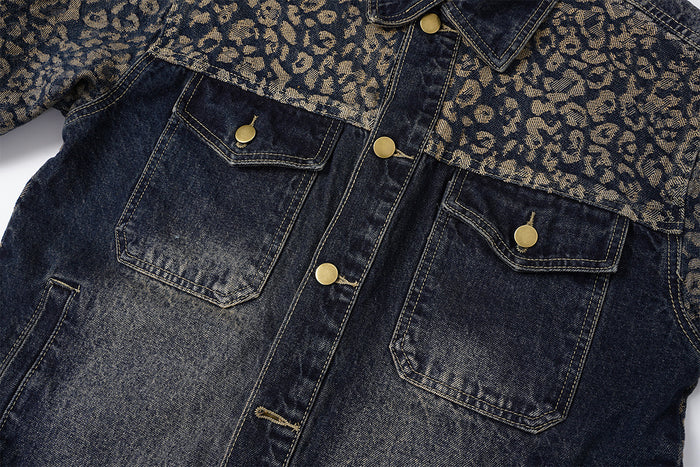 Front chest detail of a dark denim jacket with leopard-print yoke, two flap pockets, brass buttons, and contrast stitching
