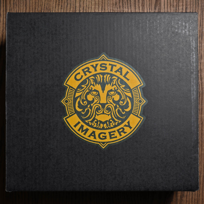 The closed matte-black Crystal Imagery gift box seen from above, with the gold Crystal Imagery lion crest centered on the lid.
