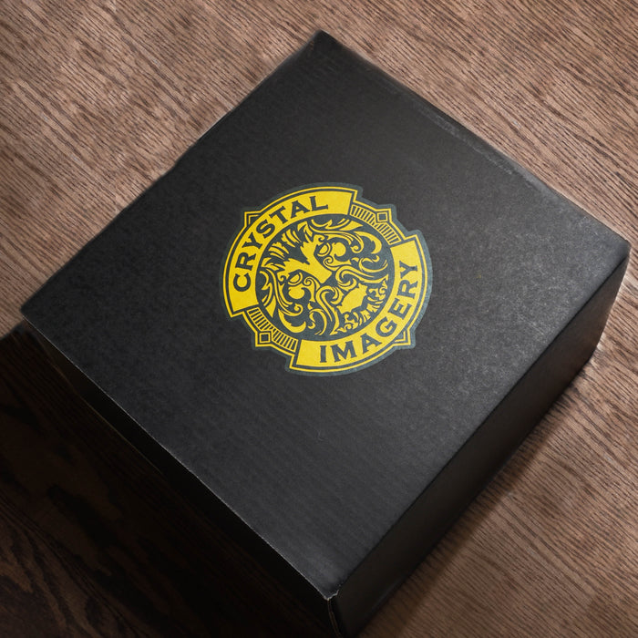 The closed matte-black Crystal Imagery gift box at a three-quarter angle, with the gold Crystal Imagery lion crest on the lid.