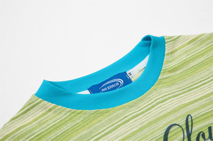 Green striped graphic T-shirt with bright blue ribbed collar and cat-themed print detail
