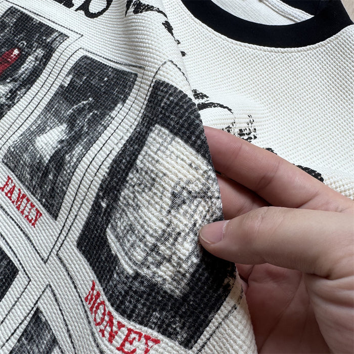 Close-up showing the cream waffle-knit fabric and distressed black graphic panels with red captions