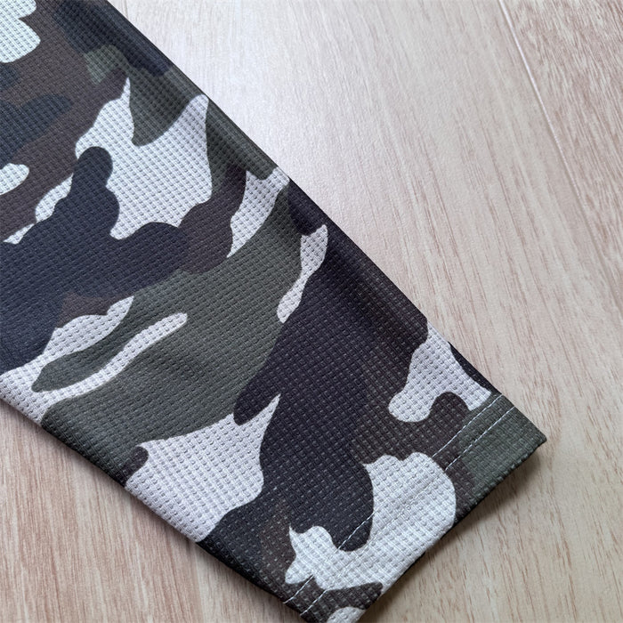 Close-up of a camouflage sleeve ending in a stitched cuff with cream, olive, and dark gray pattern