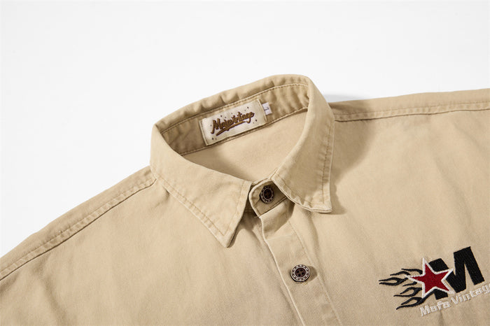 Close-up of khaki shirt collar, top buttons, and chest embroidery