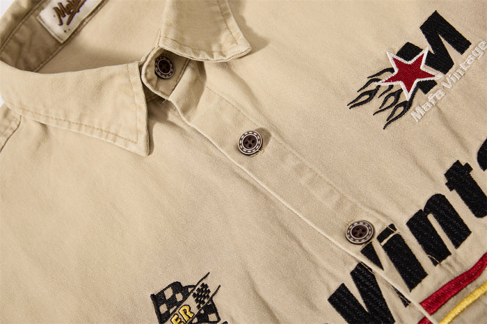 Close-up of embroidered chest design and button placket on khaki shirt