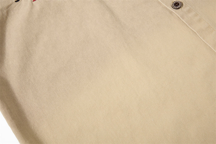 Close-up of plain khaki shirt fabric and front seam detail