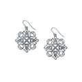 A pair of silver-colored, intricate pattern earrings designed to resemble calligraphy.