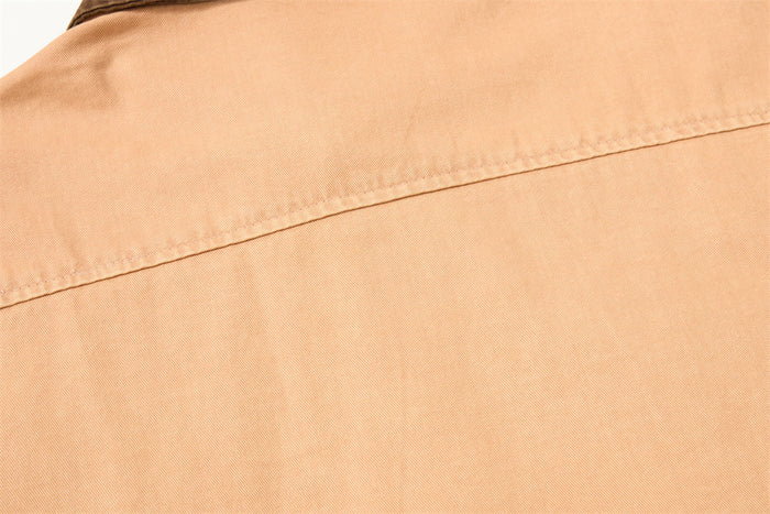 Close-up of the tan shirt back highlighting the horizontal yoke seam and smooth woven fabric