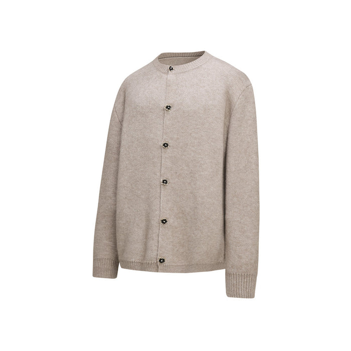 Beige knit cardigan shown at a slight angle, displaying the floral button closure and ribbed cuffs
