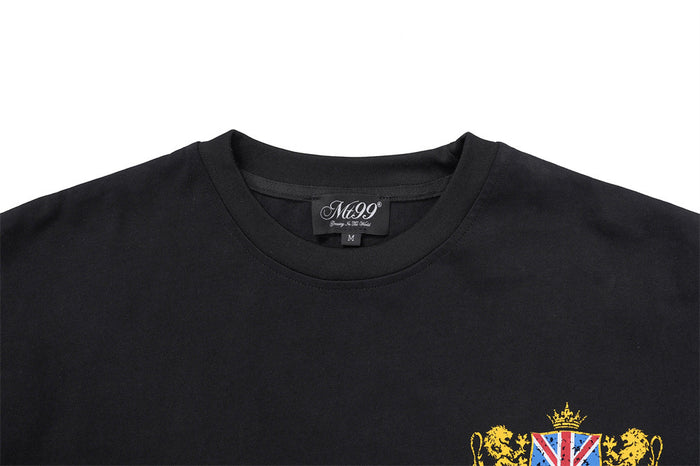 Close-up of the black crew neckline and upper chest, showing the edge of a colorful heraldic crest graphic