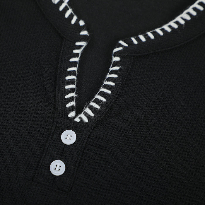Black men’s Henley V-neck T-shirt with white contrast stitching and two-button placket close-up