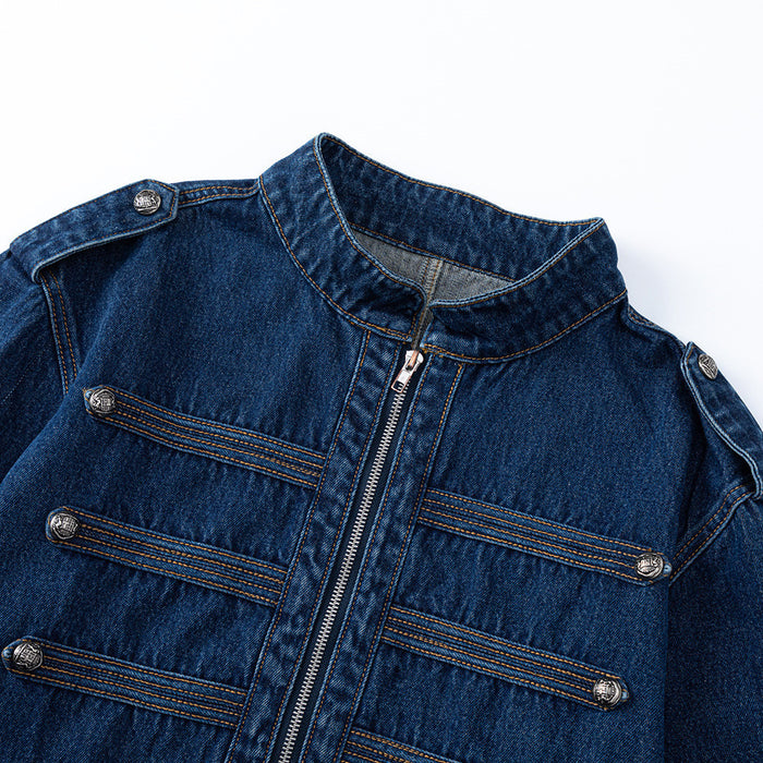 Upper front detail of a dark blue denim jacket with stand collar, shoulder tabs, zipper, and horizontal buttoned trim