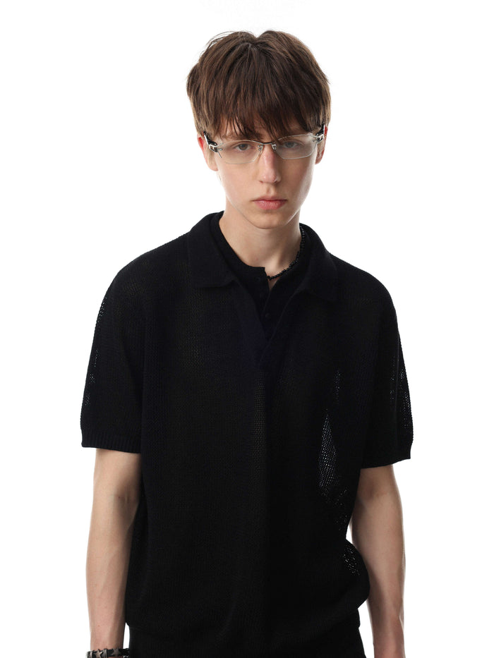 Black open knit polo shirt with short sleeves on a male model against a white background