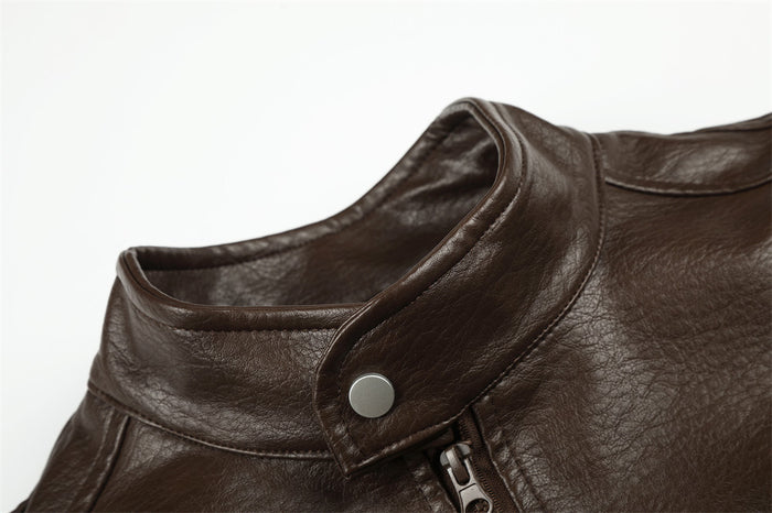 Close-up of the brown jacket's stand collar with snap button and center zipper