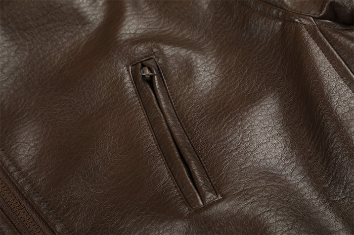 Close-up of the brown PU leather jacket's angled zippered chest pocket