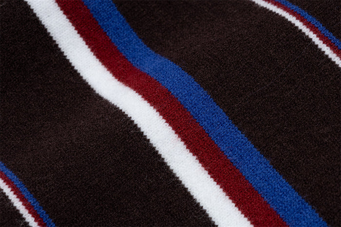 Detailed view of brown knit fabric with raised blue, red and white horizontal stripes