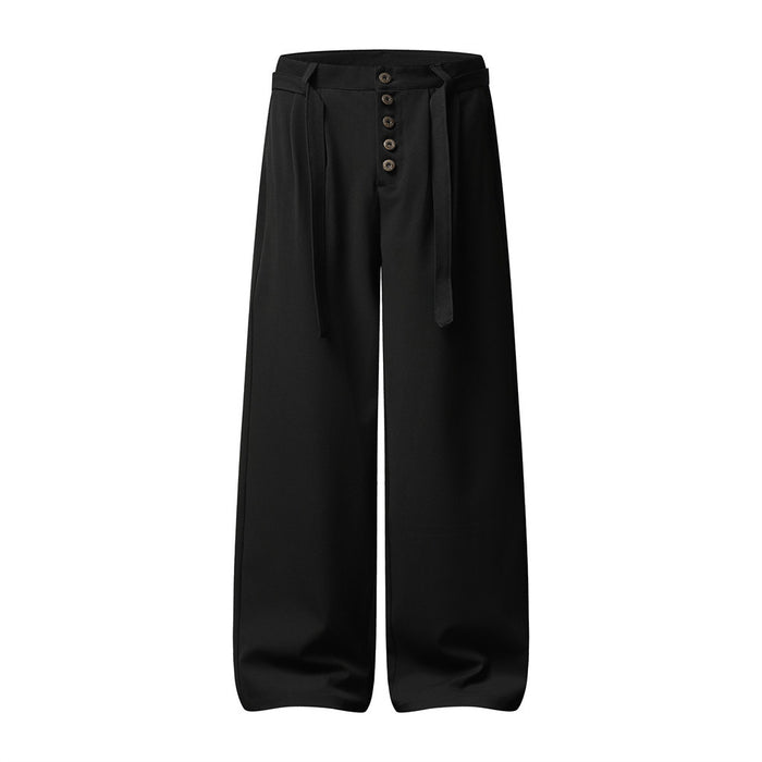 Front view of black wide-leg trousers with pleats, five-button fly, belt loops, and hanging belt tabs