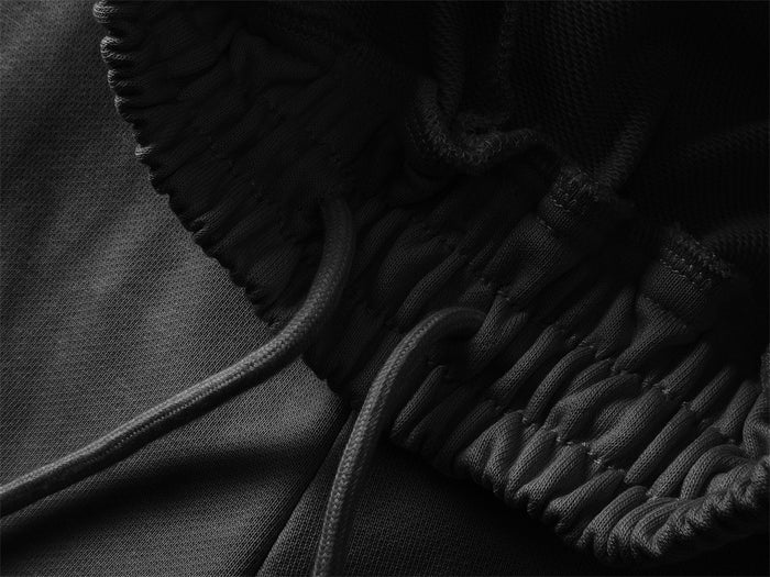 Close-up of the black elastic waistband with an adjustable drawstring and stitched seam detail