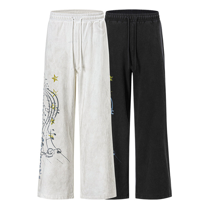 Wide-leg sweatpants in white and black with elastic waists and music note graphics on the outer legs
