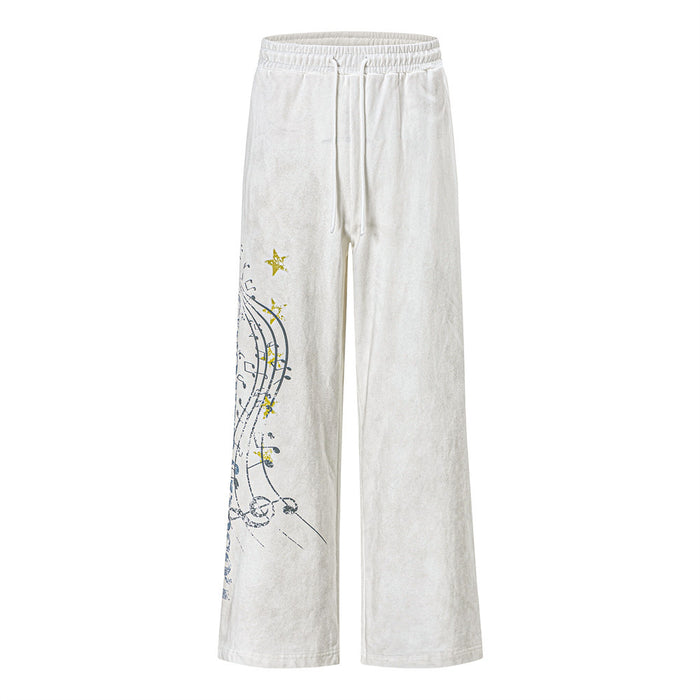White wide-leg sweatpants shown from the front with a music note and star graphic on the left leg