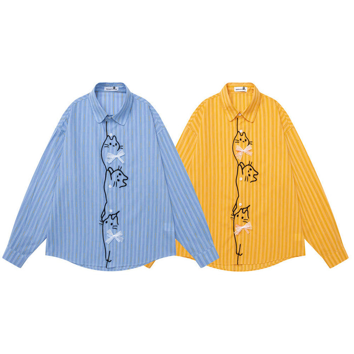 Oversized striped long-sleeve button-down shirt with cartoon cat embroidery and bow details on front placket, shown in yellow