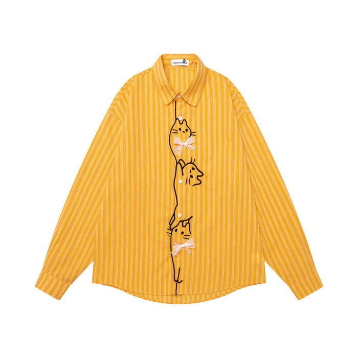 Front view of a mustard yellow vertically striped shirt with long sleeves, cat embroidery, and bow details