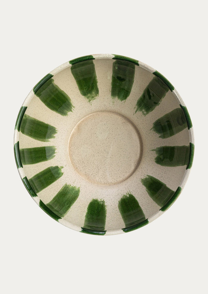 A large ceramic bowl in white with painted vertical green stripes.