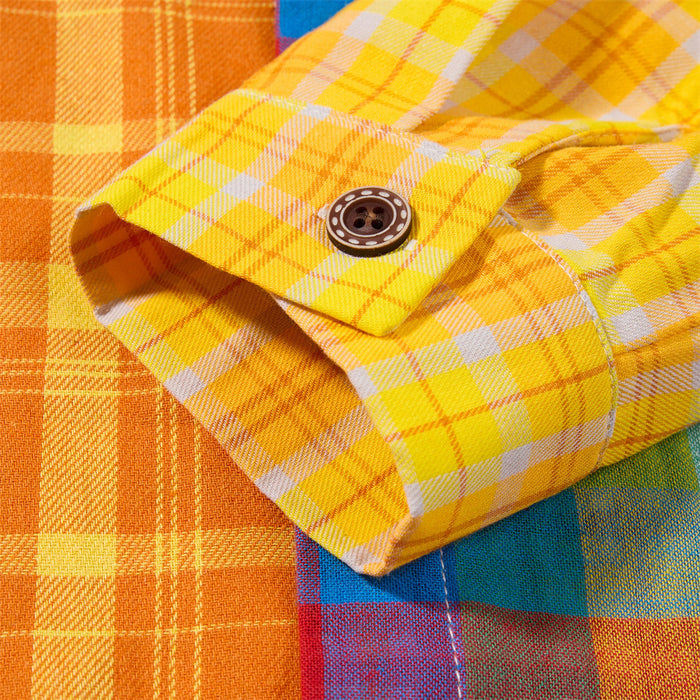 Close-up of the yellow plaid sleeve cuff showing its button fastening and contrasting multicolor shirt panels