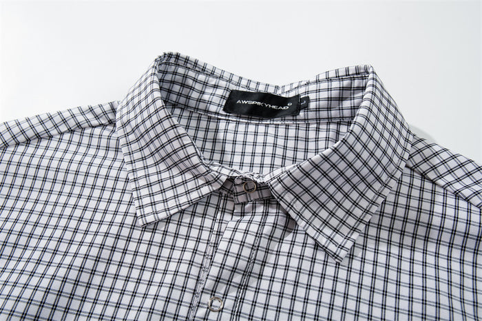 Close-up of the white plaid shirt collar, neckline, top button, and inner label