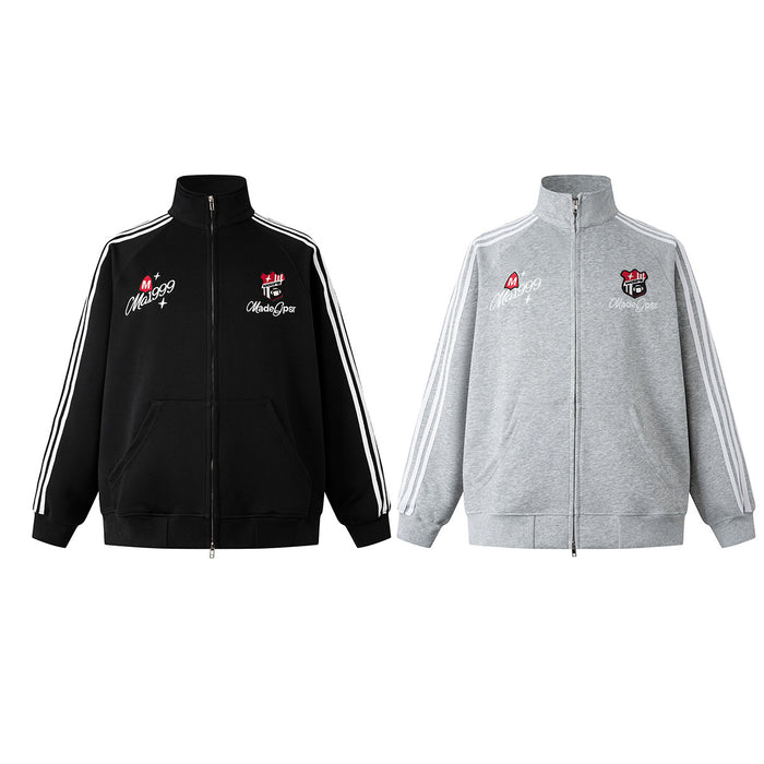 Front view of black and gray track jackets with white three-stripe sleeves and embroidered chest badges