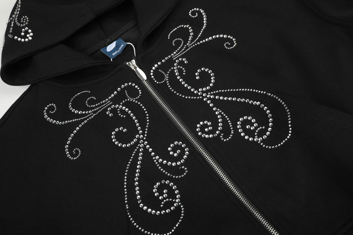 Close-up of the black hoodie front showing silver rhinestone scrolls around the central zipper