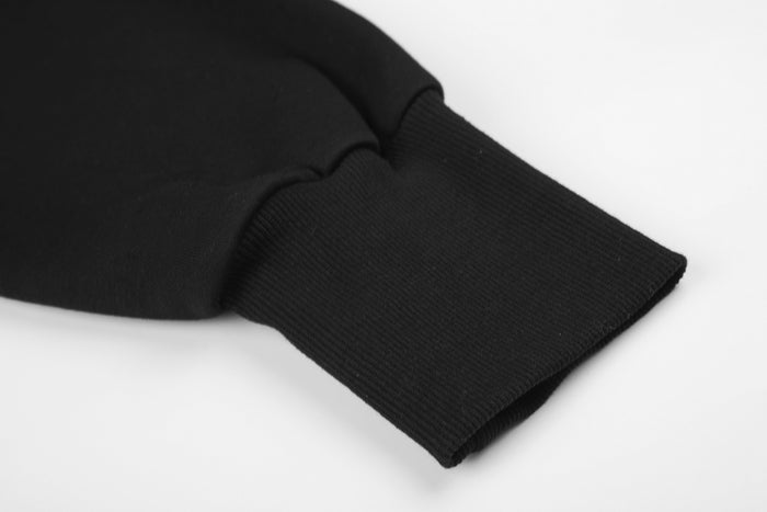 Close-up of the black hoodie sleeve ending in a wide ribbed knit cuff