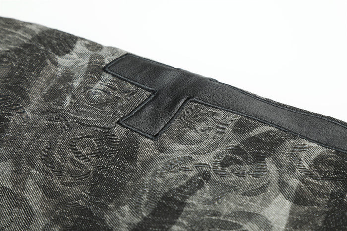 Close-up of the dark patterned jacket back showing the upper portion of a black cross-shaped patch