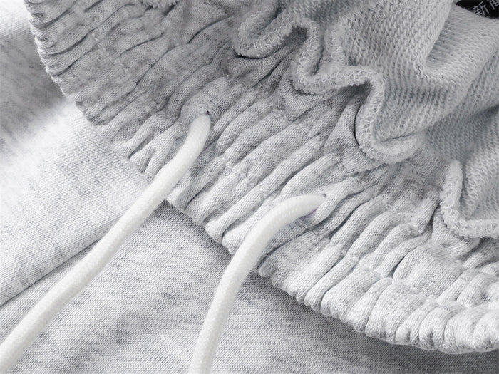Close-up of the sweatpants waistband showing gathered stitching, white drawstrings, and the inner seam