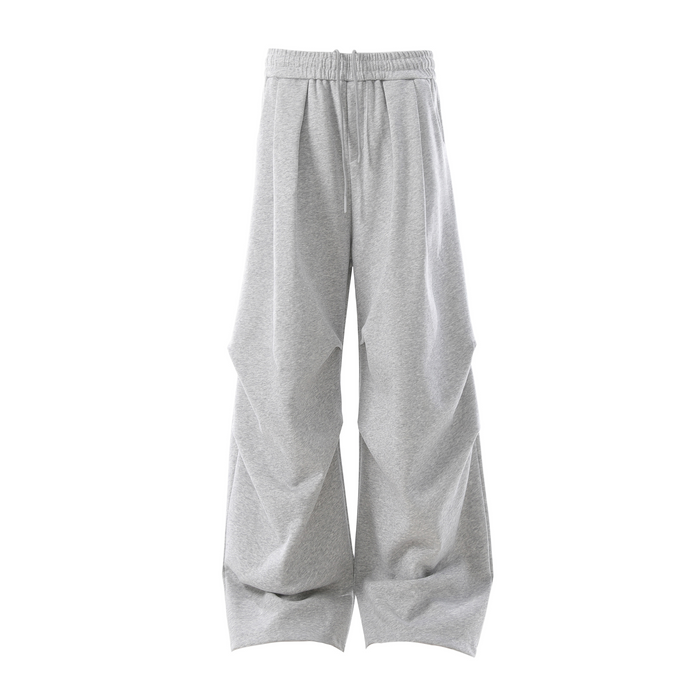 Light gray wide-leg sweatpants front view with pleated sculpted panels and drawstring waist