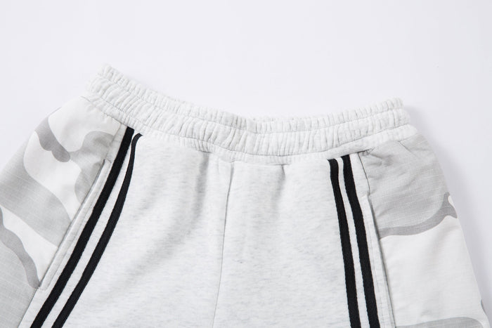 Close-up of elastic waistband and front top of light gray sweatpants with black stripes