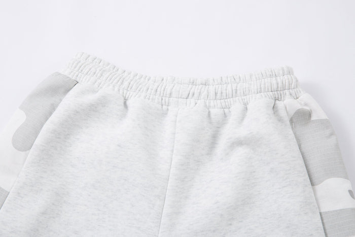 Close-up of elastic back waistband on light gray sweatpants with camo side panels