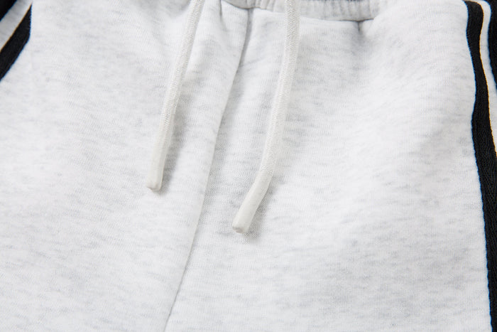 Close-up of adjustable drawstring at the waist of light gray sweatpants