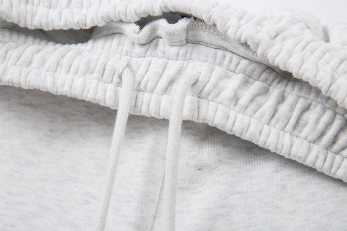 Close-up of elastic waistband stitching on light gray sweatpants