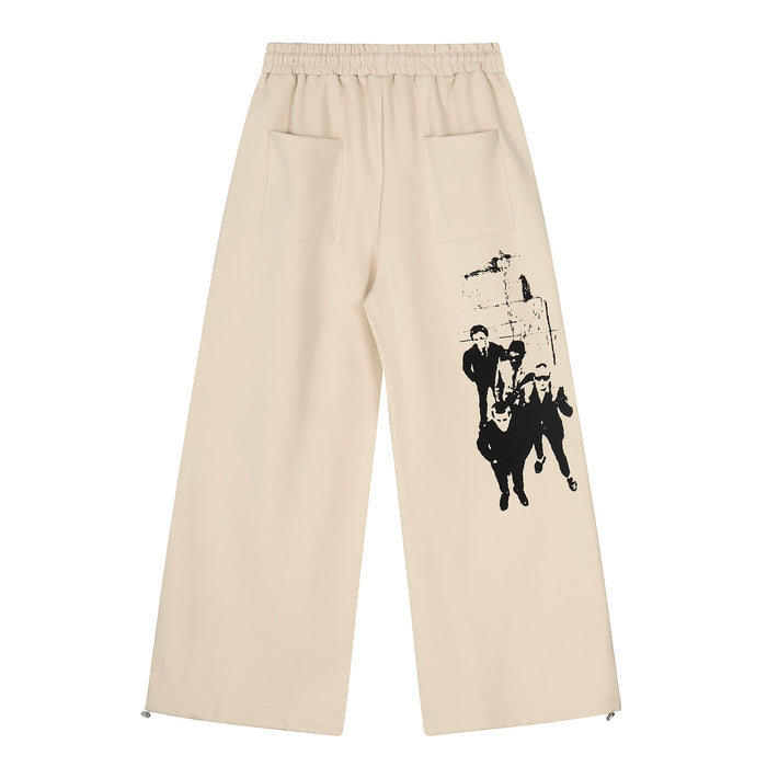 Beige wide-leg pants back view with large rear pocket and black graphic on one leg
