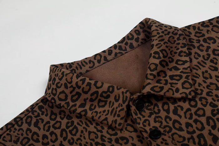 Brown leopard print polo tee with black buttons and open collar in a close-up streetwear fashion detail