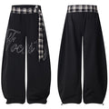 Black barrel-fit track pants with plaid waistband tie and cursive Focus script print, shown front and back