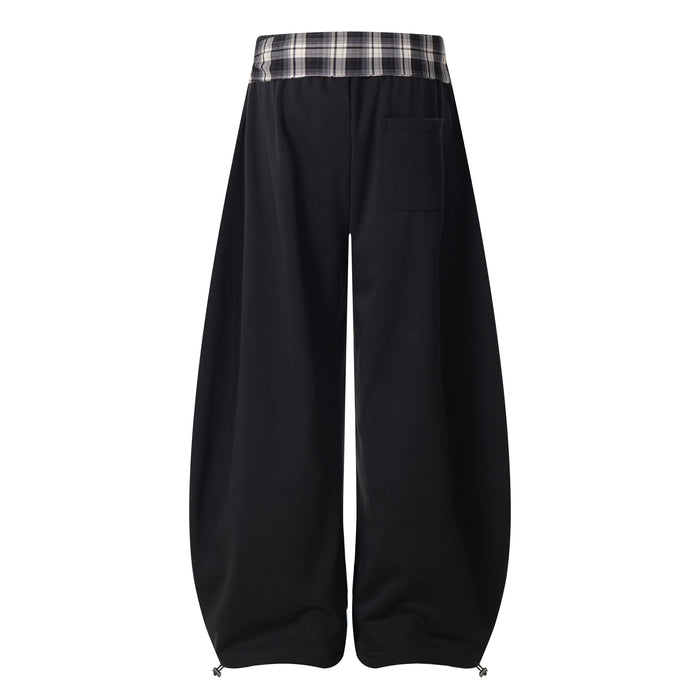 Back view of black barrel track pants with plaid waistband and rear patch pocket