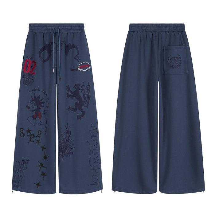 Navy wide-leg sweatpants with all-over sketch graphics, heraldic lion print, embroidered emblems, and drawstring waist, front