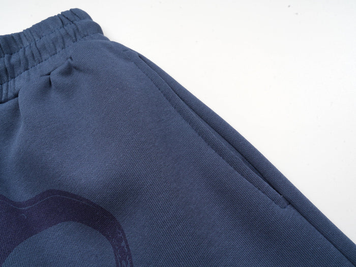 Close-up of smooth navy fabric and side seam on the sweatpants leg