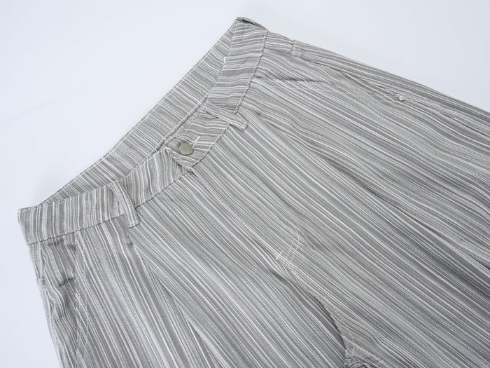 Close-up of the front waistband on gray striped pants with button closure and belt loops